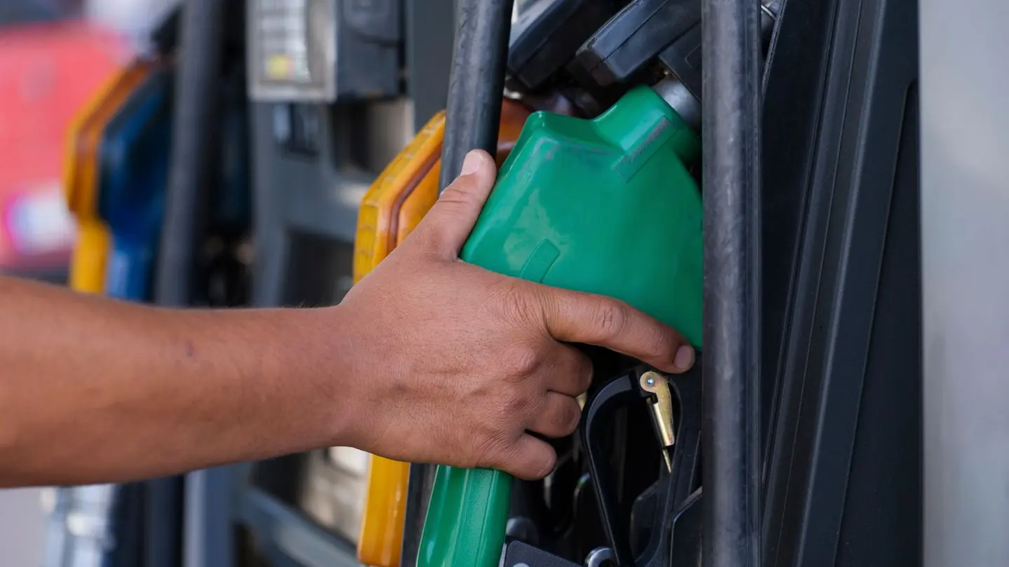A person hand holding a gas pump.