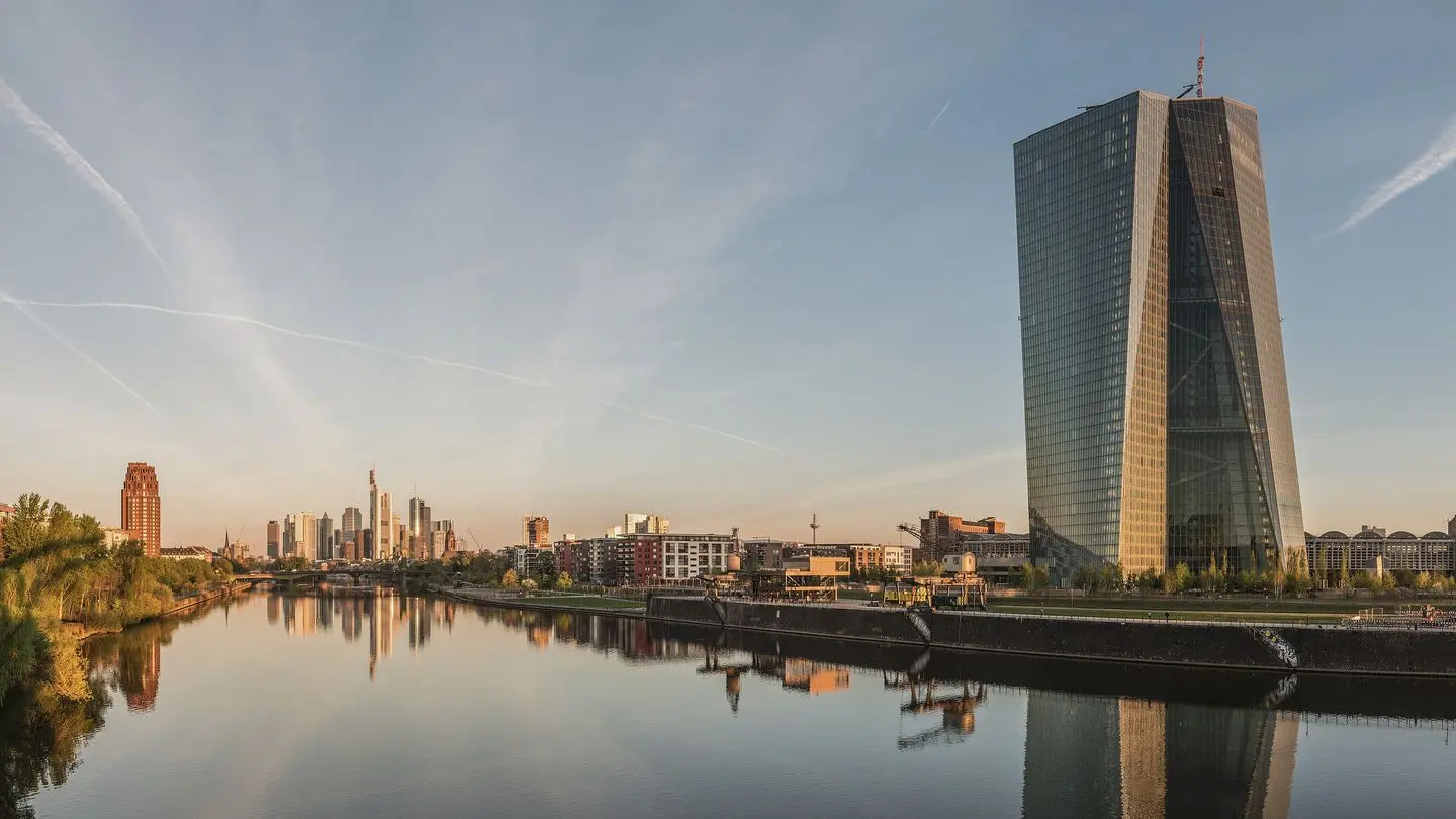 The European Central Bank tower in Frankfurt at dawn, with the city skyline along the river Main