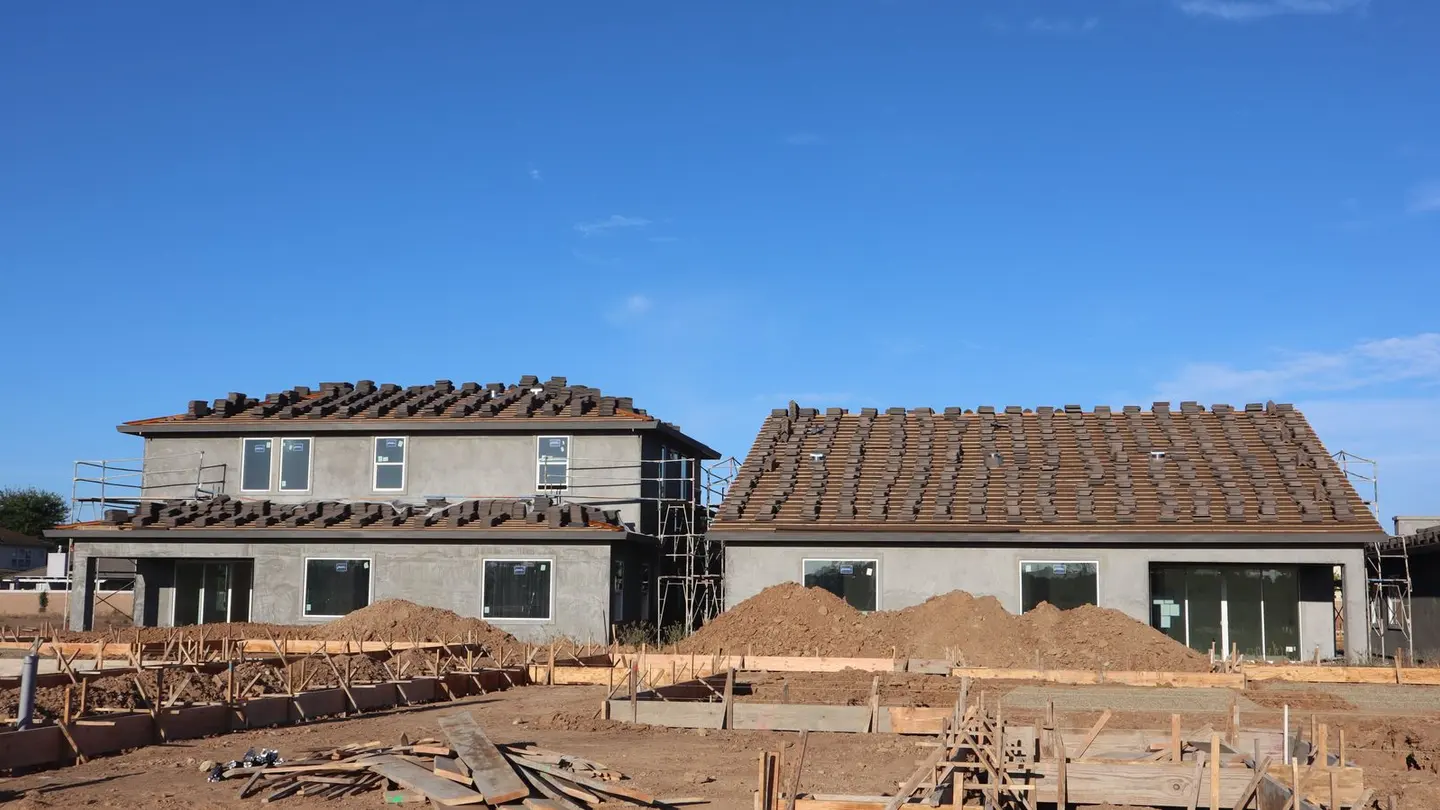 Newly constructed houses under blue sky.