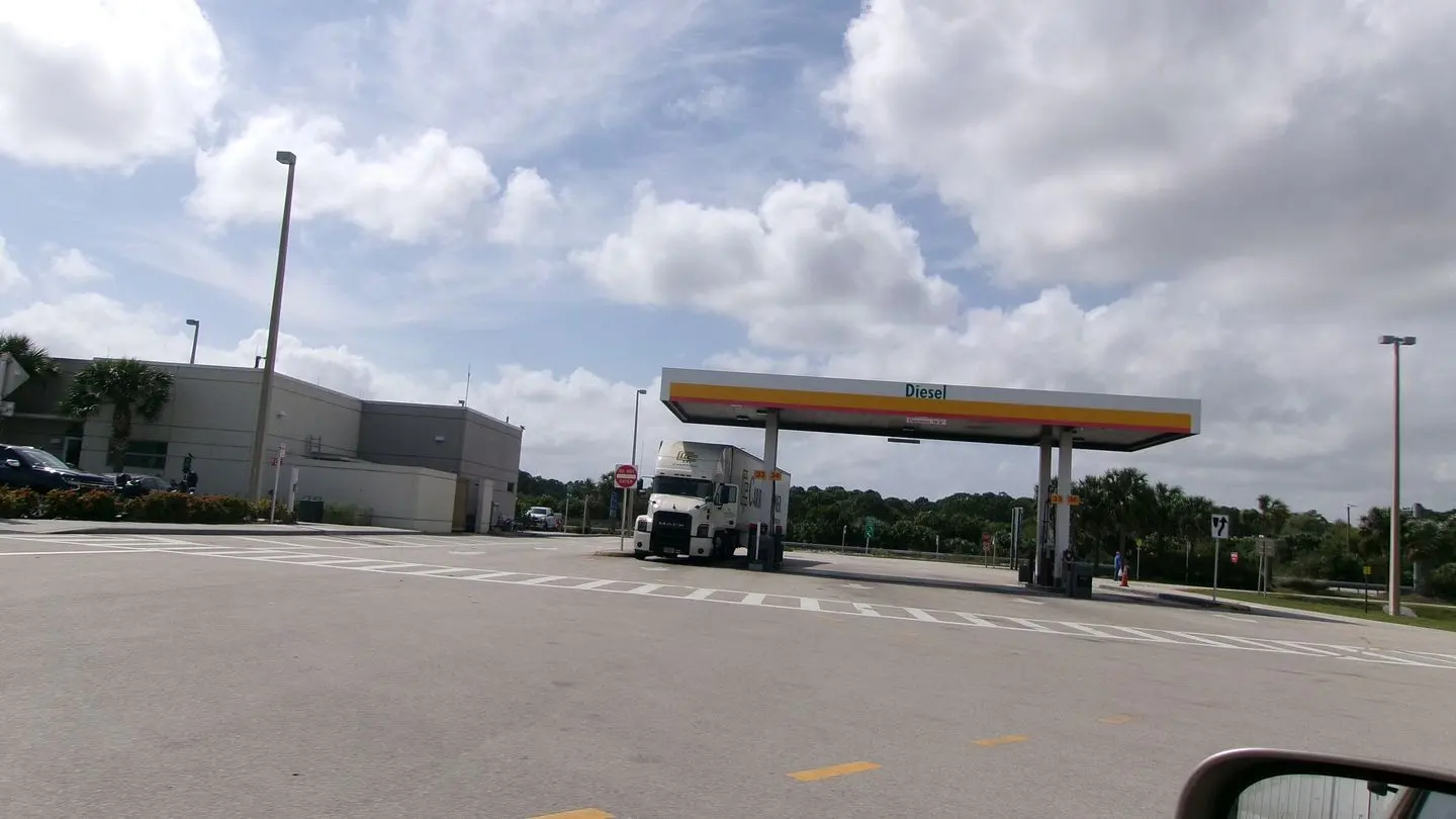 Diesel pumps and a truck under a service plaza canopy in Fort Pierce, Florida